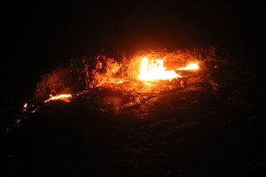 an explosion illuminates the crater floor