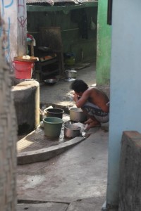 a man washing the dishes in his courtyard