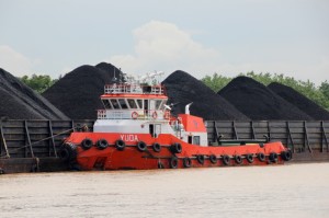 tow boat next to a coal barge