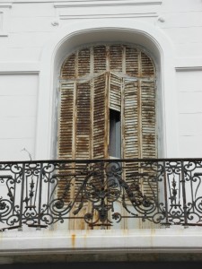 and one of its typical balconies in front of shuttered windows