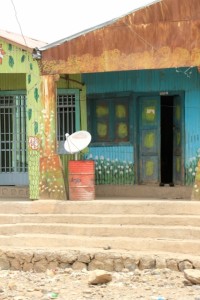 Dichioto satellite dish, in front of colourfully painted corrugated iron