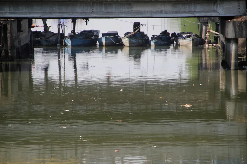 small boats moored under a bridge