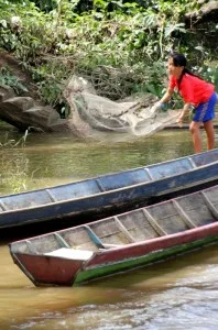 girl fishing along the river bank
