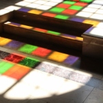 the modern stained-glass windows of the Capriani Monastry church reflected on the floor 