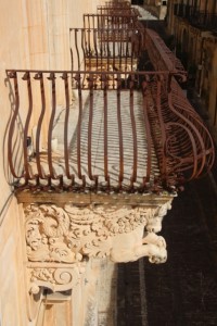 the wrought-iron balconies, here with horses